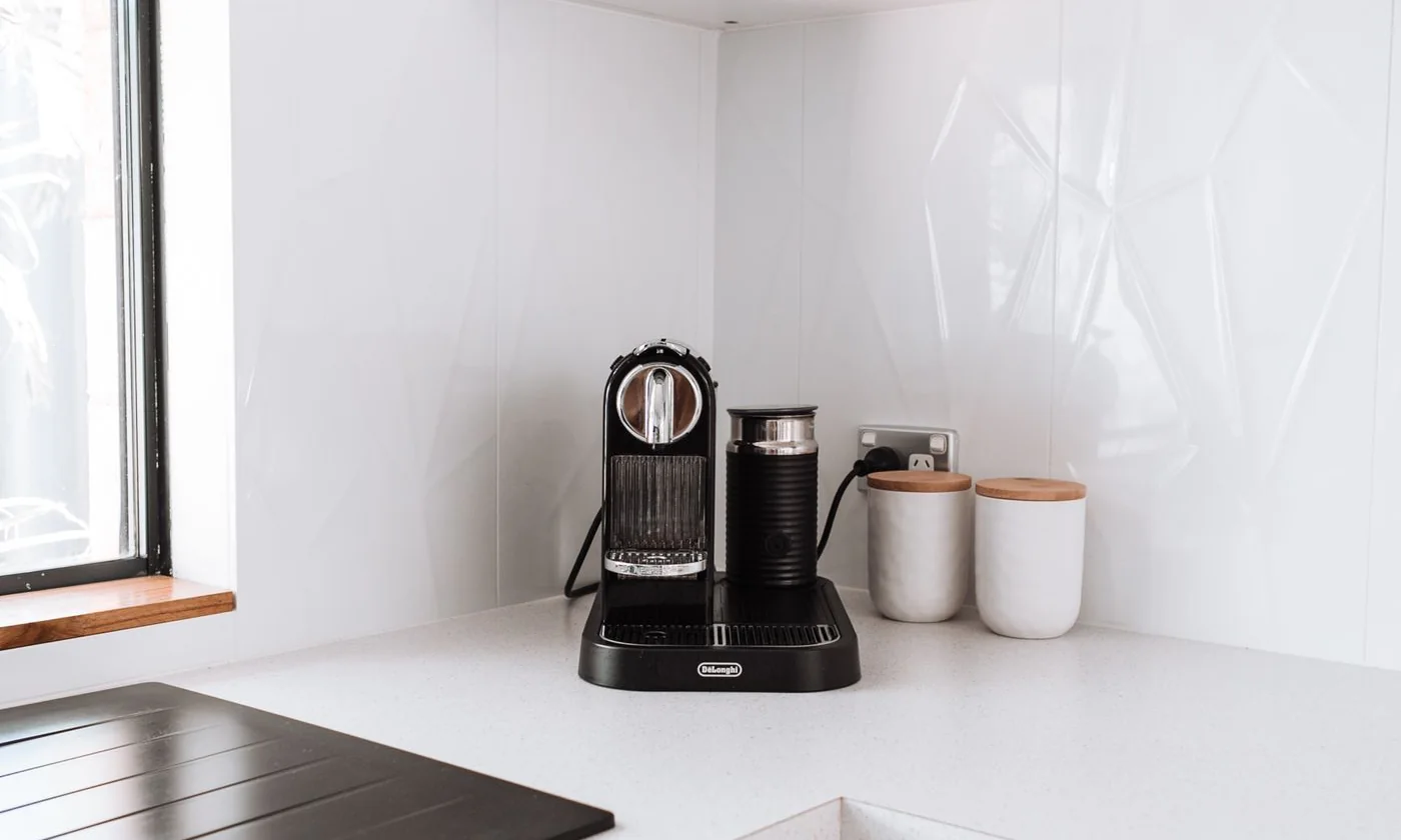 Coffee maker and mugs on a white kitchen counter