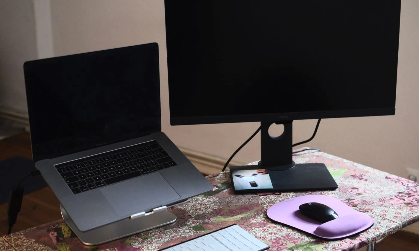 A laptop and external monitor arranged with a keyboard and mouse on a desk